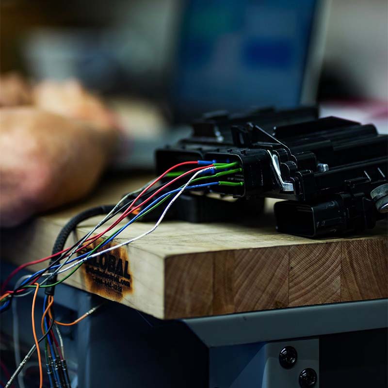 Diesel ECM connectors and wiring harness on a tuning bench